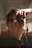 A person holding a camera up to their face, capturing a close-up reflection or self-portrait in a mirror. The image has a soft focus with warm lighting, emphasizing the intimate and personal nature of the scene.