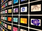 Colorful digital art pieces framed on a wall.