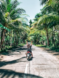 A happy tourist riding a motorbike on a scenic Dalat mountain road.