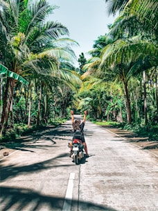 A happy tourist riding a motorbike on a scenic Dalat mountain road.