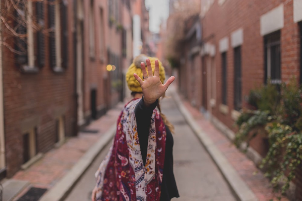 woman in red and black coat holding yellow fruit