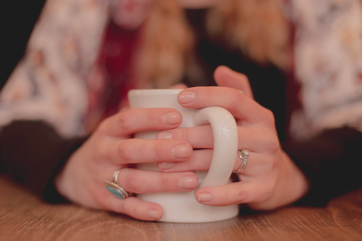 Cold hands wrapped around a warm mug