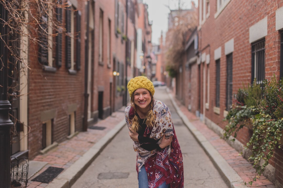 woman in red and white floral hijab standing on sidewalk during daytime