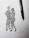 A black ink drawing on white paper depicts two abstract human figures embracing or dancing. The sketching style is rough and dynamic, capturing a sense of movement and connection. A black pen is placed beside the drawing, suggesting the tool used to create it.