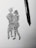 A black ink drawing on white paper depicts two abstract human figures embracing or dancing. The sketching style is rough and dynamic, capturing a sense of movement and connection. A black pen is placed beside the drawing, suggesting the tool used to create it.
