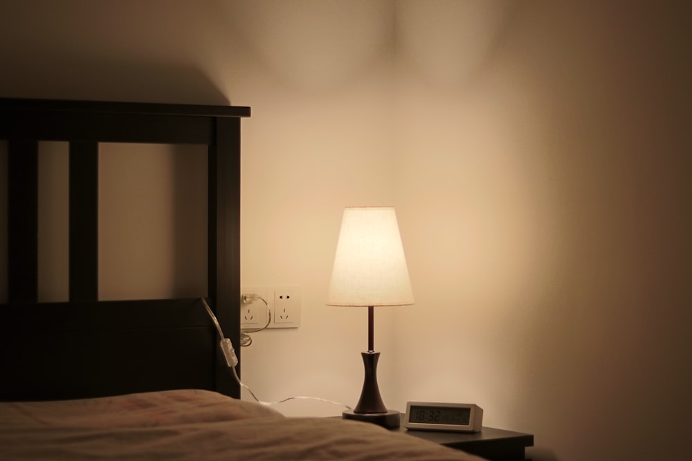 white and black table lamp on brown wooden table