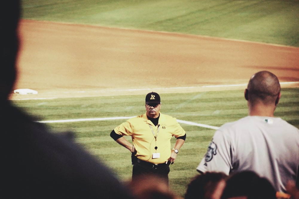 man in white and black polo shirt standing on green grass field during daytime