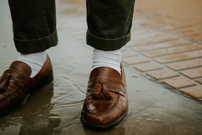 person in brown leather shoes