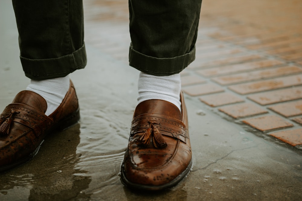 person in brown leather shoes