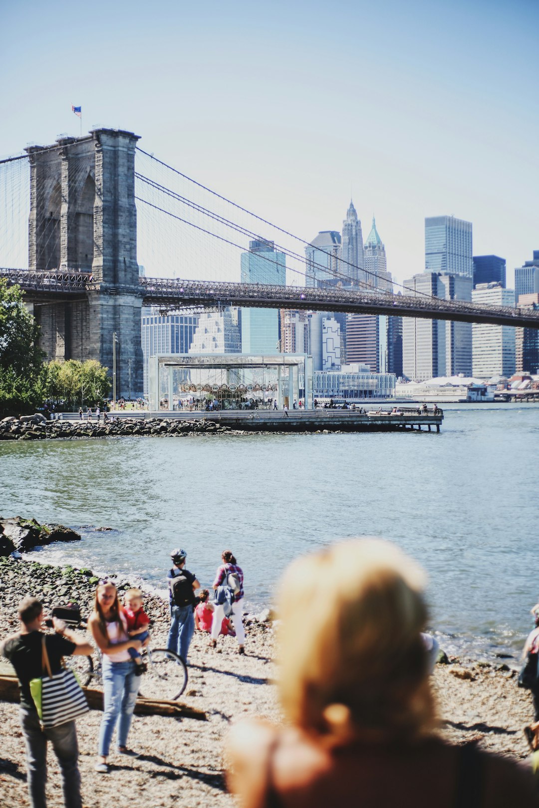 people on beach near bridge during daytime