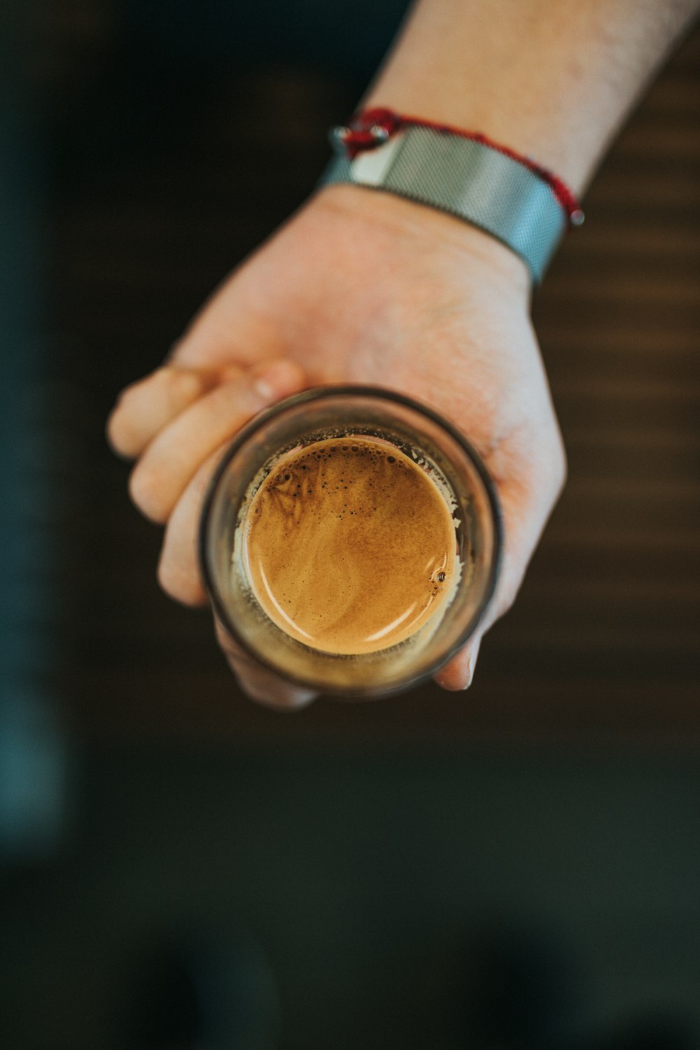 person holding brown and white ceramic mug