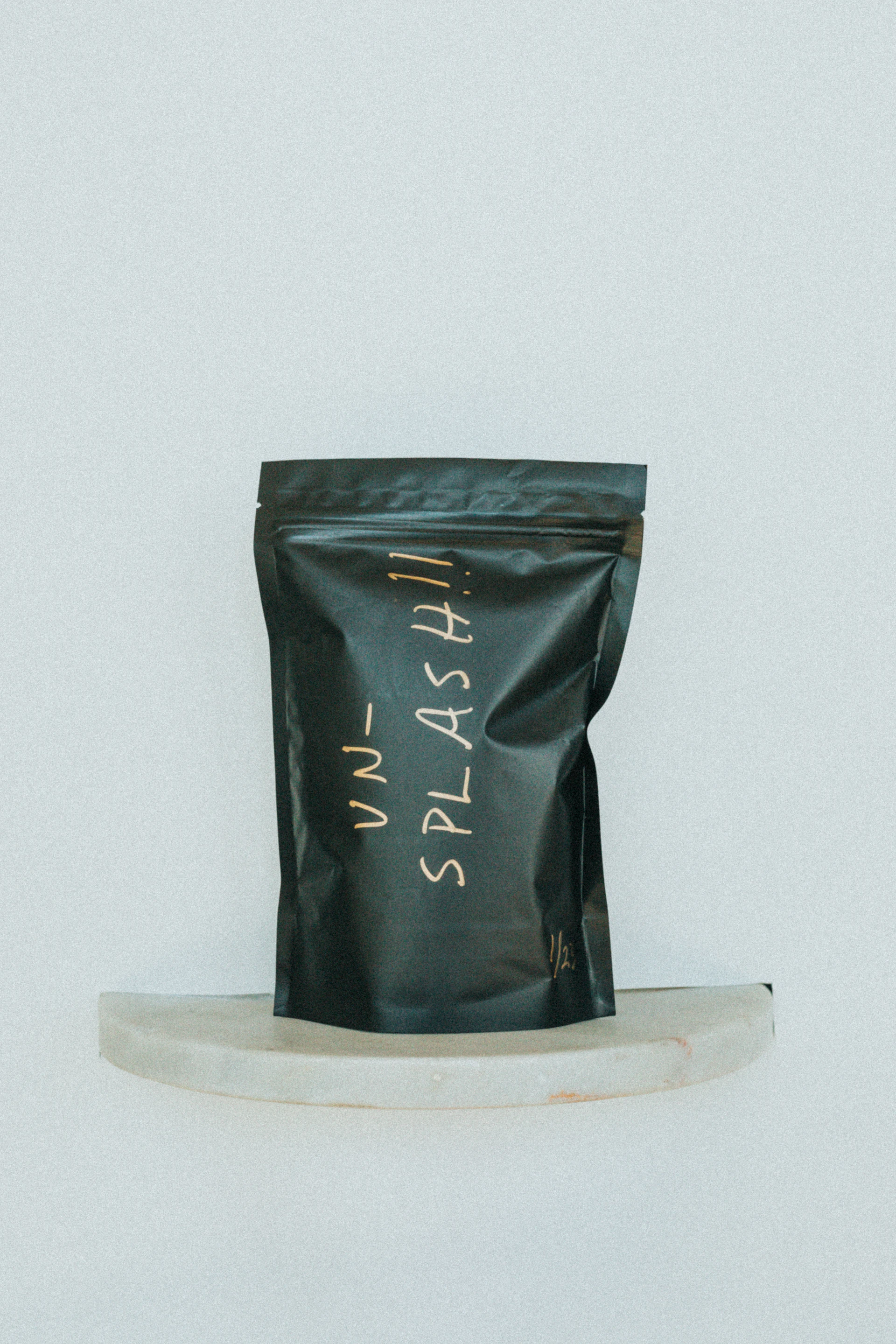 A warm, inviting scene of a customer holding a perfectly packed pasta box, the golden logo shining subtly on the matte black container.