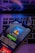 A smartphone displays a music streaming app screen titled 'Happy Hits!' along with a playlist description. The phone is placed on a laptop keyboard and two wireless earbuds rest on top. The lighting has a purple and blue hue, giving a modern and digital feel.
