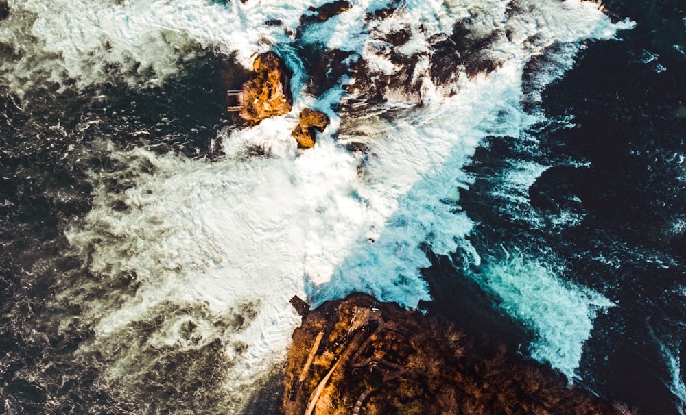 brown rock formation on body of water during daytime