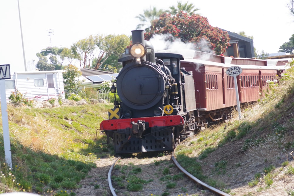 trem vermelho e preto nos trilhos ferroviários durante o dia