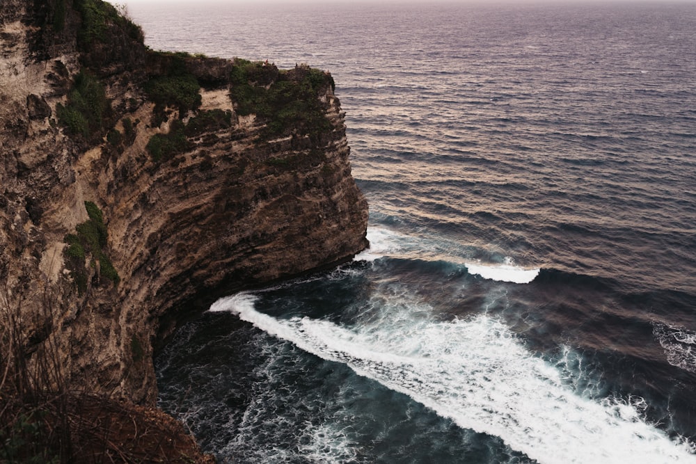 Formazione rocciosa marrone accanto allo specchio d'acqua durante il giorno