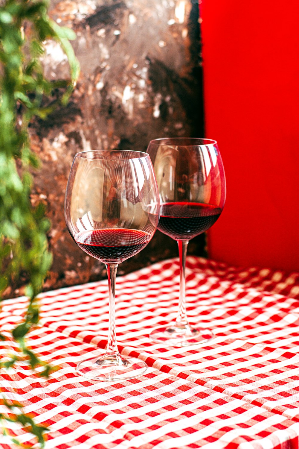 clear wine glass on red and white checkered table cloth