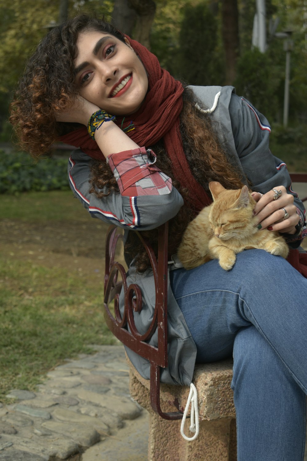 a woman sitting on a bench holding a cat