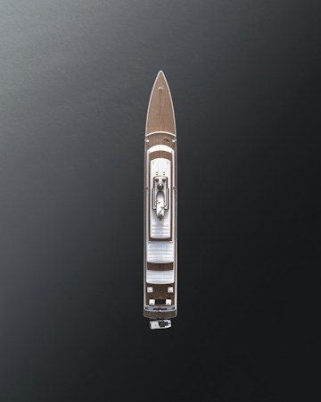 Aerial view of a large luxury yacht with a sleek design, positioned on dark, calm waters. The vessel features a wooden deck and a central structure, showcasing modern architecture with minimalistic details.