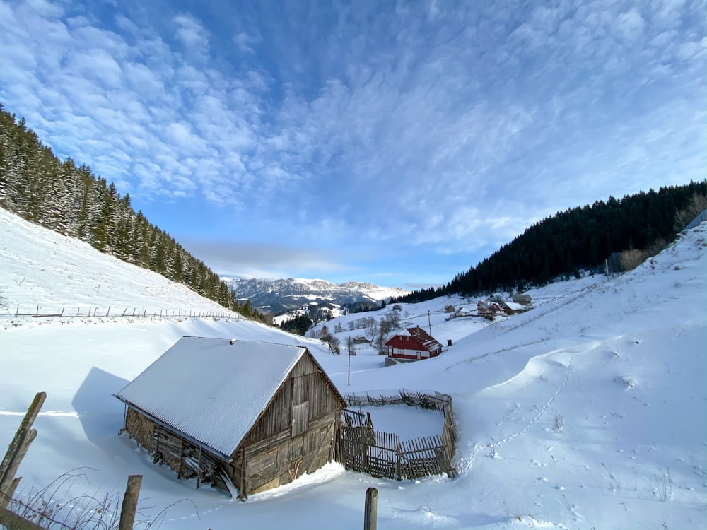 brown wooden house on snow covered ground during daytime