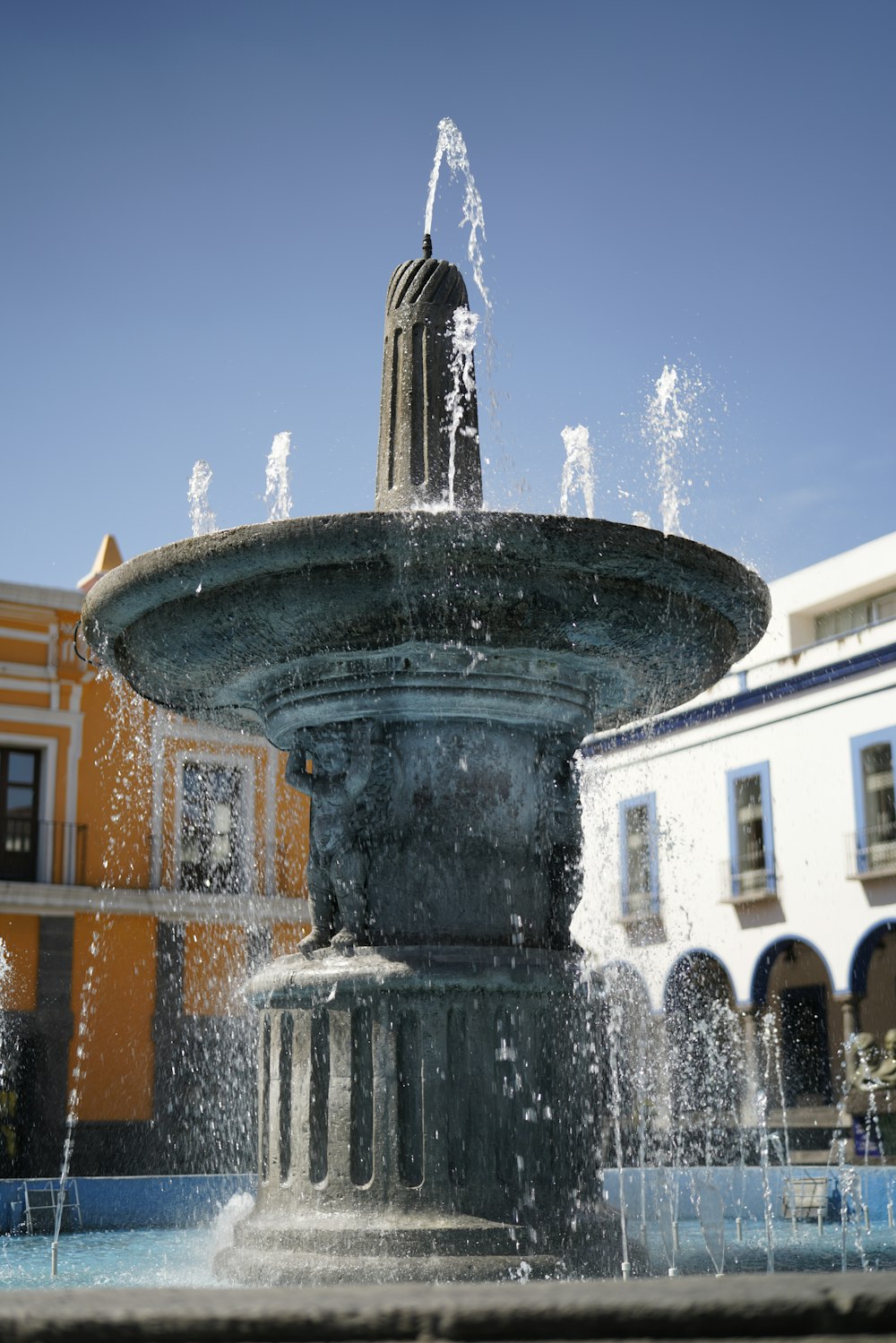 water fountain in front of brown building