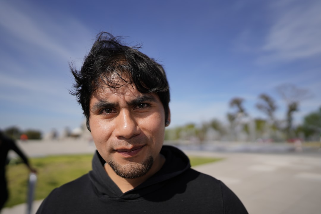 man in black hoodie standing on beach during daytime