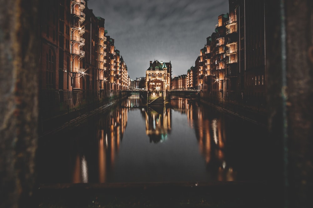 brown concrete building near body of water during night time