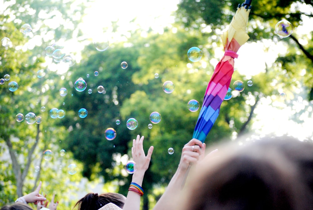 people holding multi colored balloons during daytime