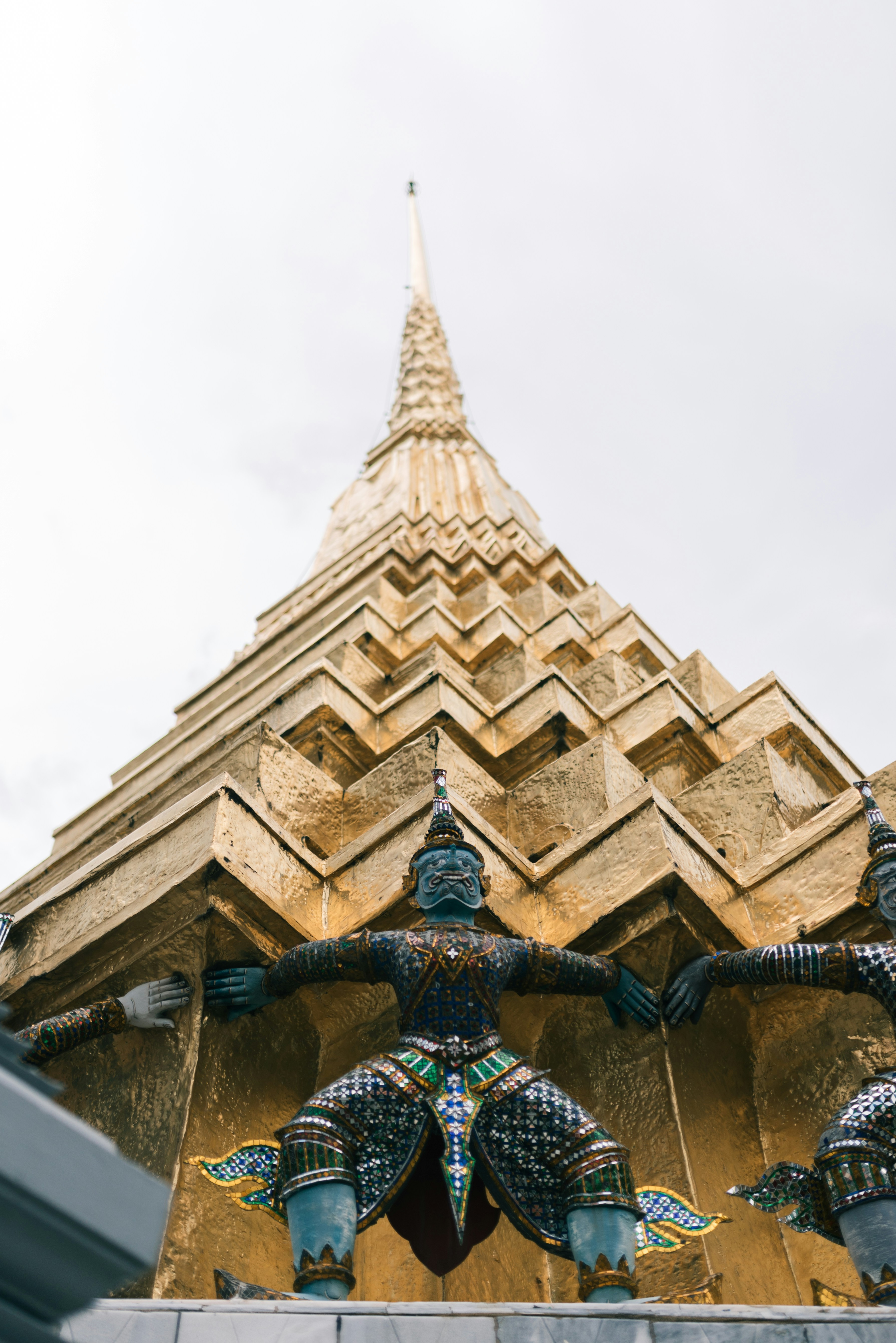 gold and blue statue on top of brown concrete building
