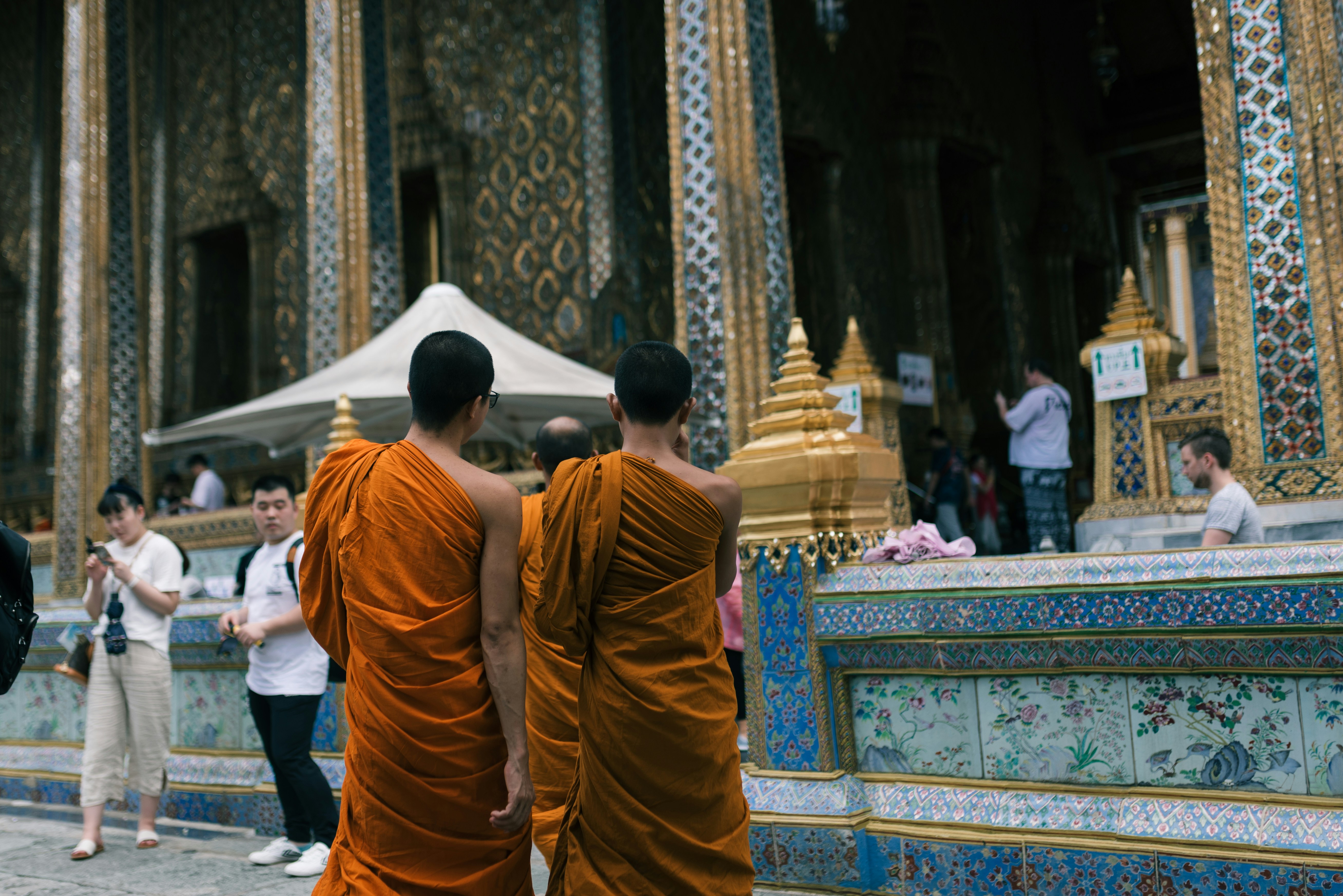 people in orange robe walking on street during daytime