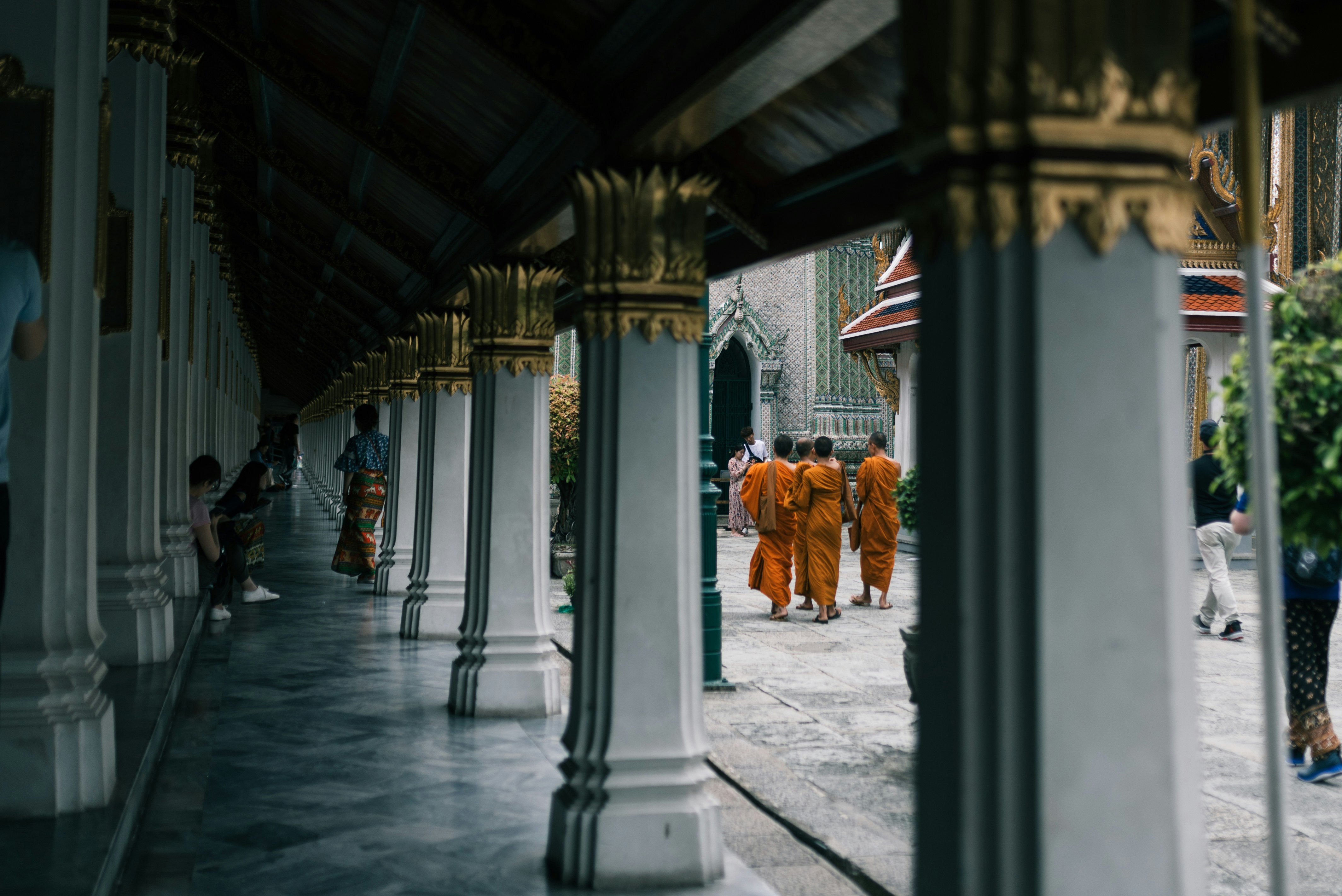 people in orange and white traditional dress walking on gray concrete pathway during daytime