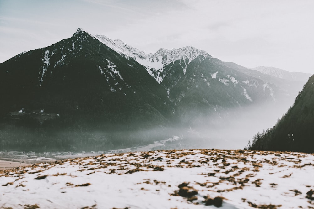 snow covered mountain near body of water during daytime