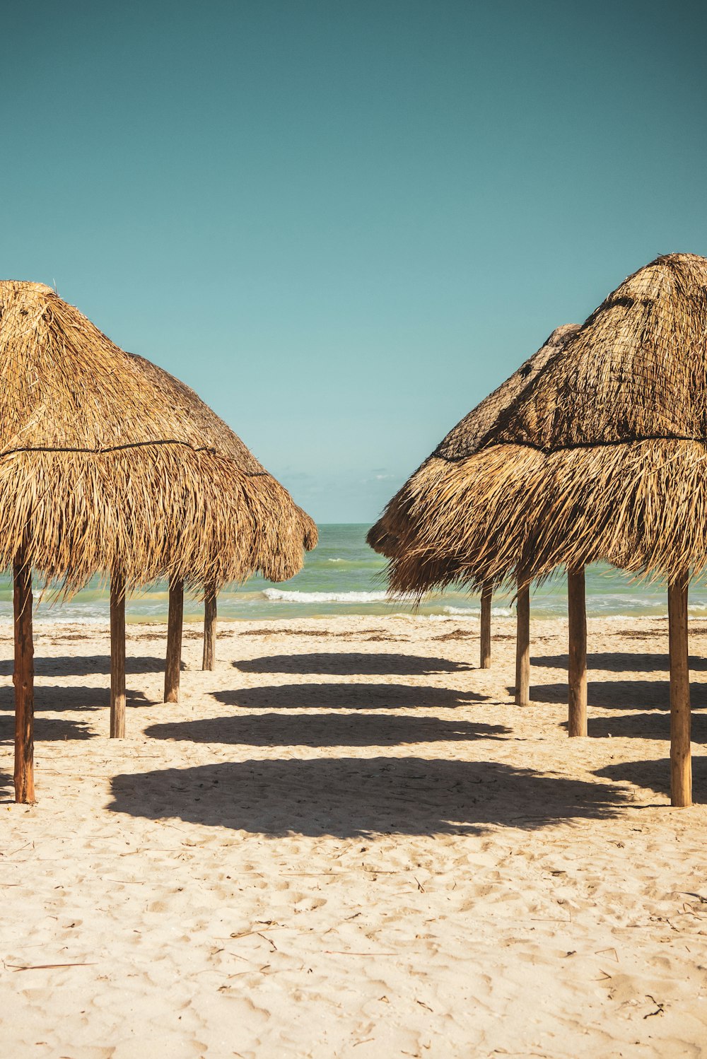 Cabaña de nipa de madera marrón en la playa durante el día