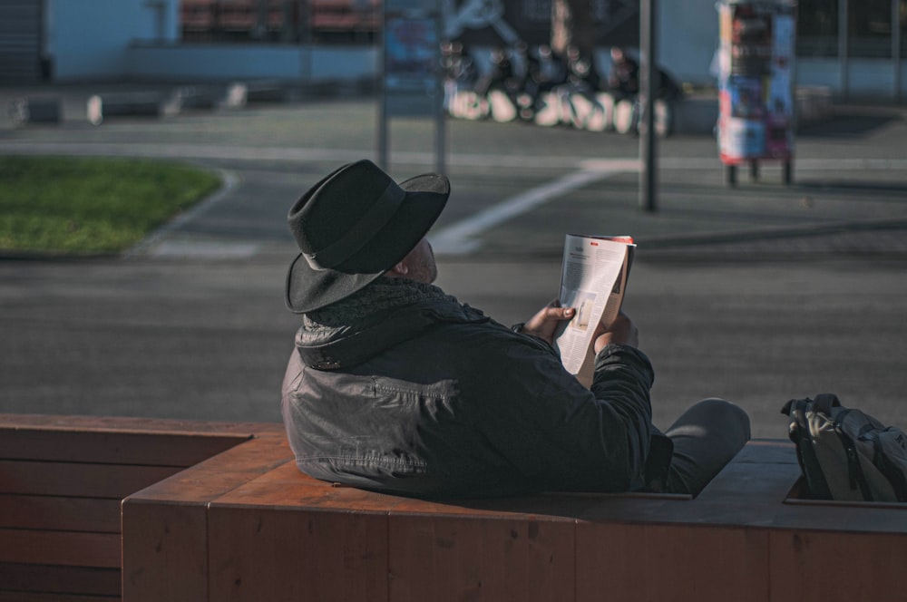 man in black hoodie reading book