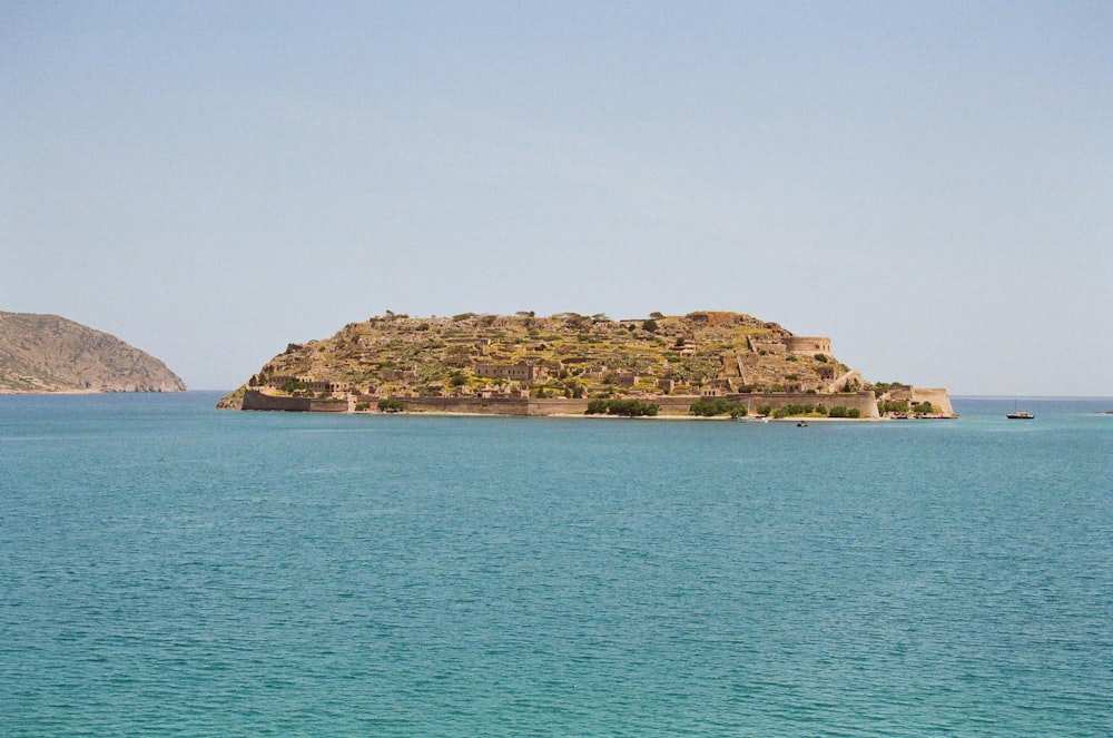 green and brown island on blue sea under blue sky during daytime