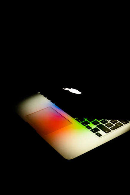 Open MacBook displaying vibrant, colorful screen with lumenova branding