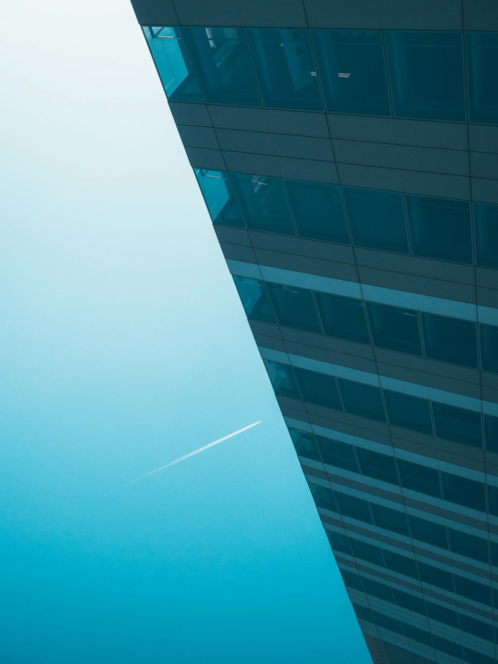 edifício de concreto branco e azul sob o céu azul durante o dia