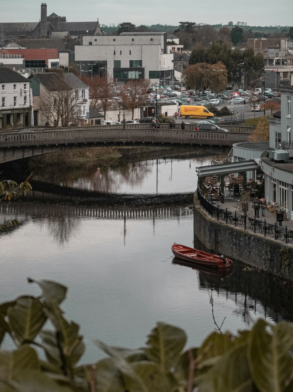 Rotes Boot tagsüber auf dem Fluss in der Nähe von Stadtgebäuden