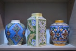 A retro Chinese ceramic vase with intricate blue patterns displayed on a vintage shelf.