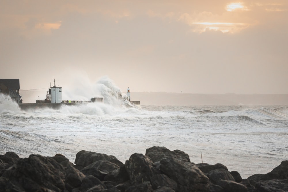 white lighthouse on rocky shore during daytime