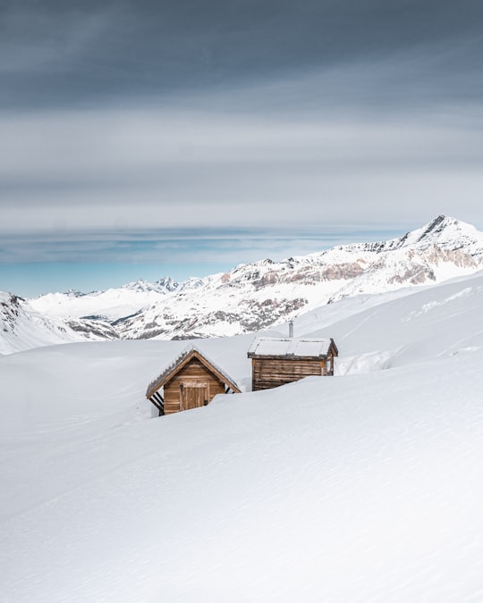 brown wooden house on snow covered ground during daytime in Val-d'Isère France