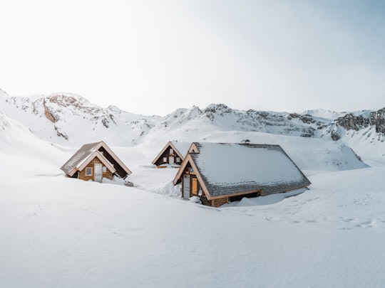 brown wooden house on snow covered ground during daytime in Val-d'Isère France