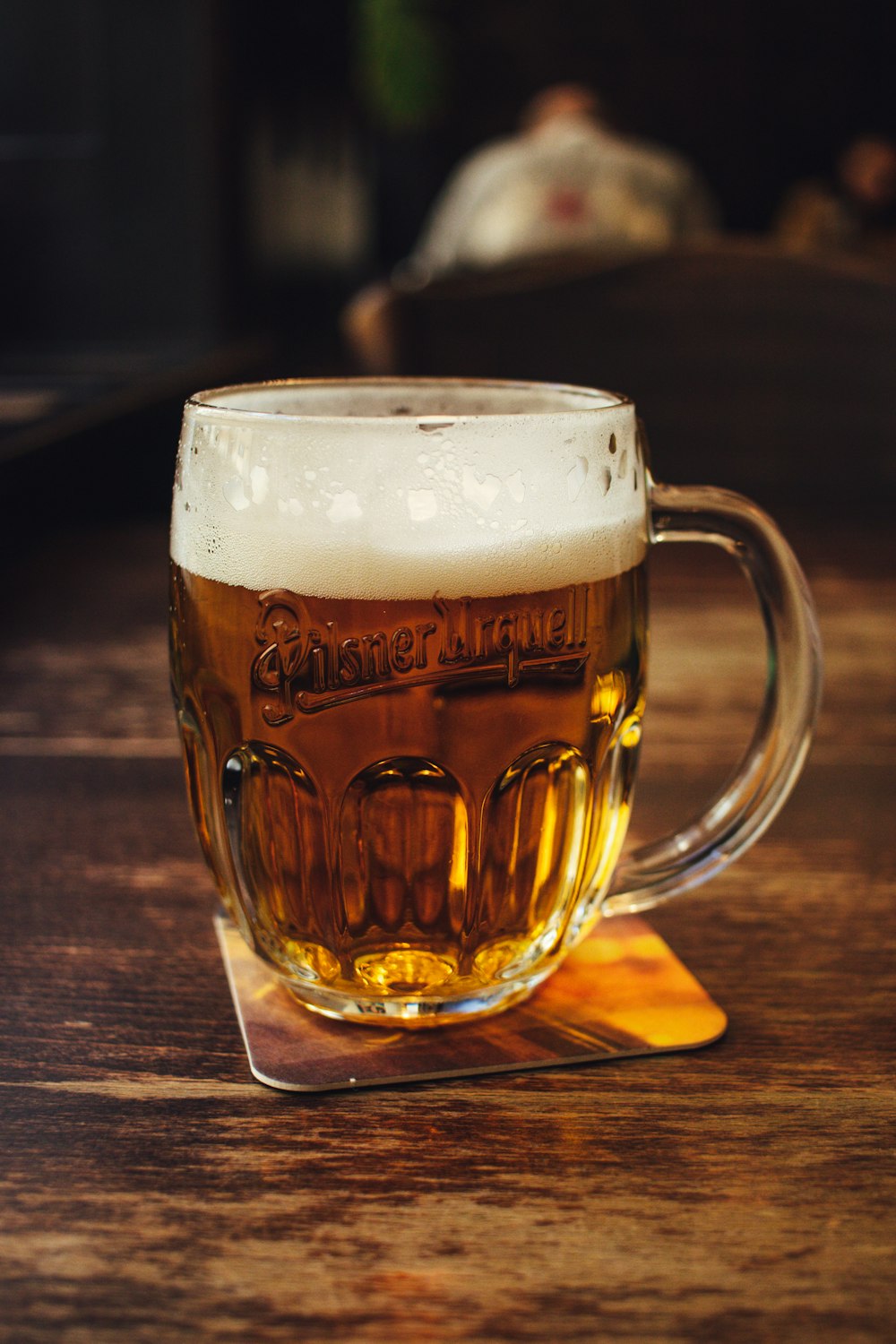 clear glass beer mug on brown wooden table