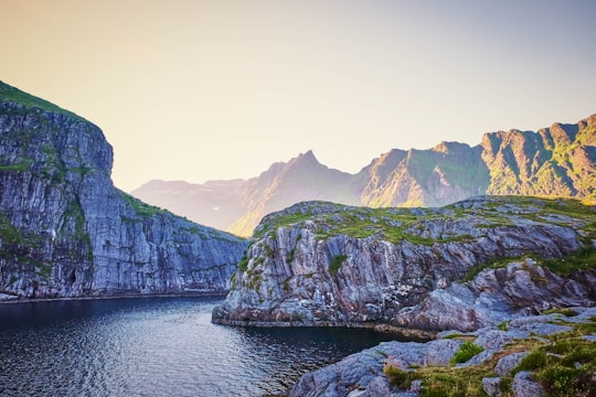 green and brown mountain beside body of water during daytime