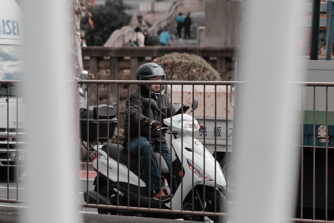 man in black jacket riding white motorcycle