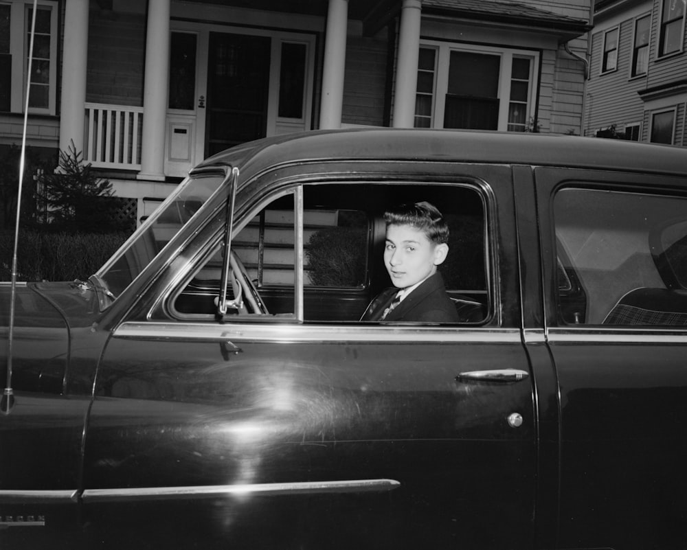 grayscale photo of woman in car