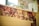 A wooden surface is adorned with numerous old photographs, showcasing various groups of smiling people. The images appear nostalgic and faded, offering glimpses of joyful gatherings, possibly in a social or family setting.
