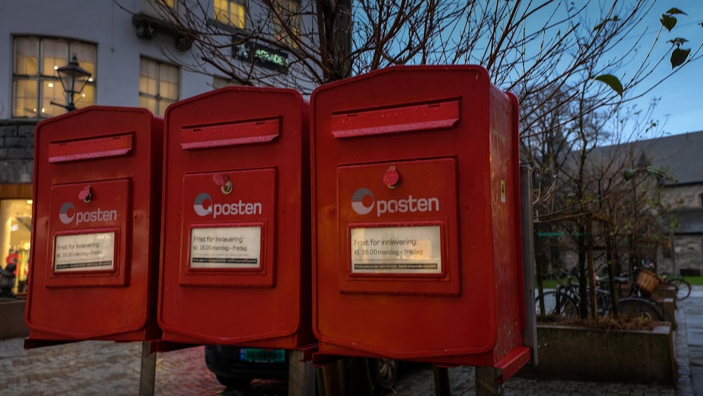 red mail box on sidewalk during daytime