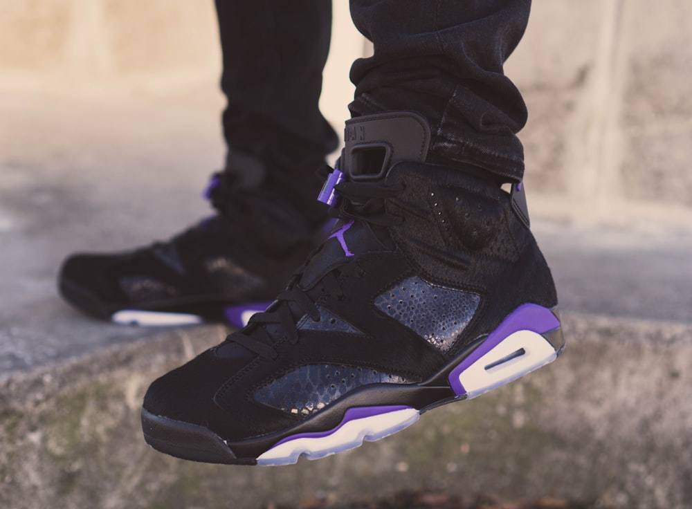person wearing black white and purple nike air max 90