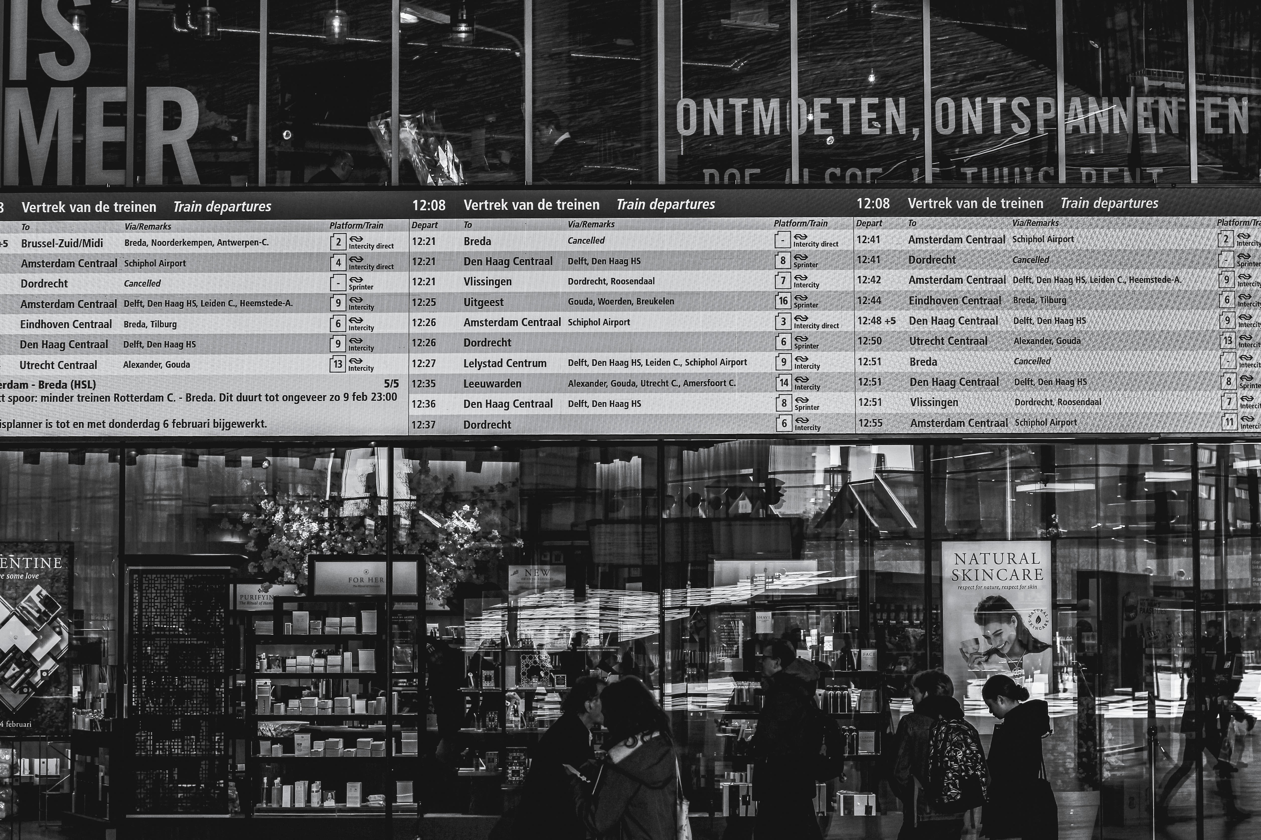 grayscale photo of people in front of store